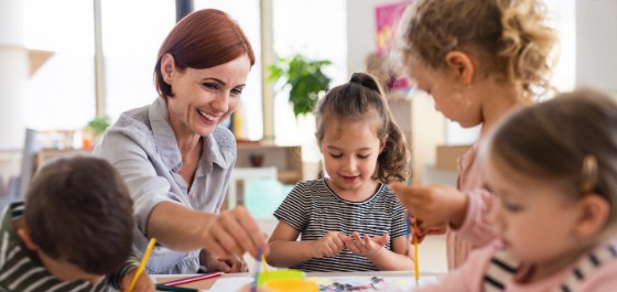 Vortragsreihe Pädagogik Eine Frau betreut Kinder in einer Kita