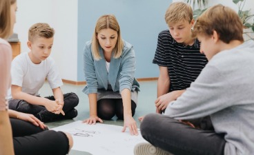 Evaluation Pädagogische Mitarbeiterin in der Kinder‑, Jugend‑ und Eingliederungshilfe Eine Gruppe Jugendlicher mit einer Mitarbeiterin des Jugendamtes
